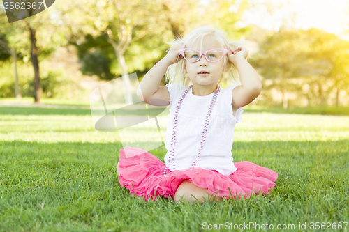 Image of Little Girl Playing Dress Up With Pink Glasses and Necklace