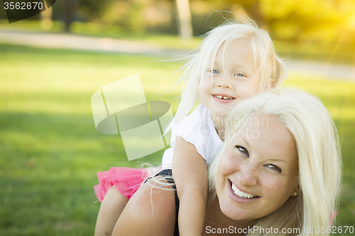 Image of Mother and Little Girl Having Fun Together in Grass