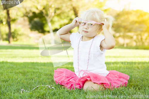 Image of Little Girl Playing Dress Up With Pink Glasses and Necklace