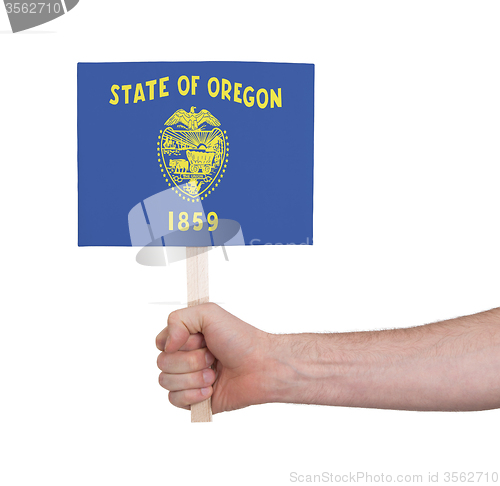 Image of Hand holding small card - Flag of Oregon