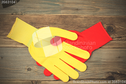 Image of handshake red and yellow construction gloves