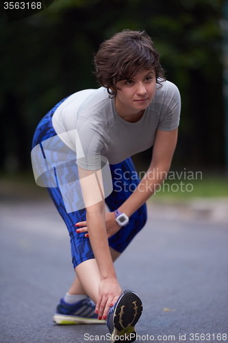 Image of woman  stretching before morning jogging