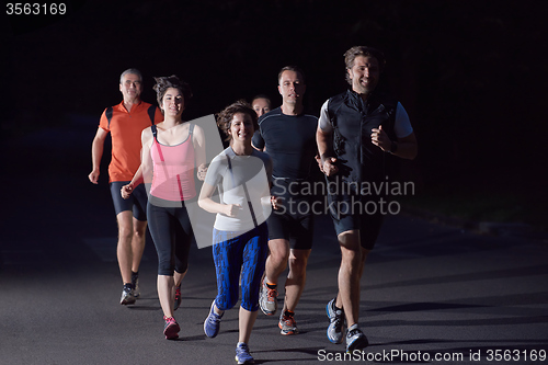 Image of people group jogging at night