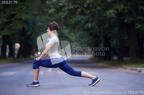 Image of woman  stretching before morning jogging