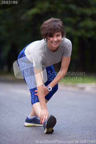 Image of woman  stretching before morning jogging