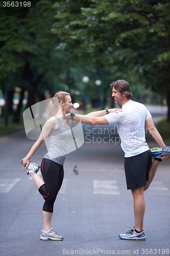 Image of jogging couple stretching