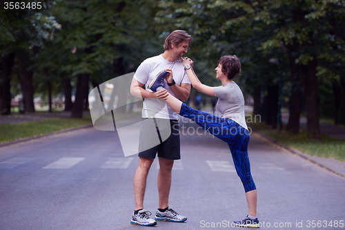 Image of jogging couple stretching