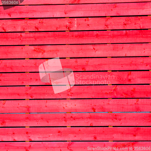 Image of red wall in old construction nail and house