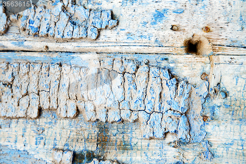 Image of metal nail dirty stripped paint in blue