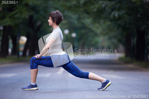 Image of woman  stretching before morning jogging