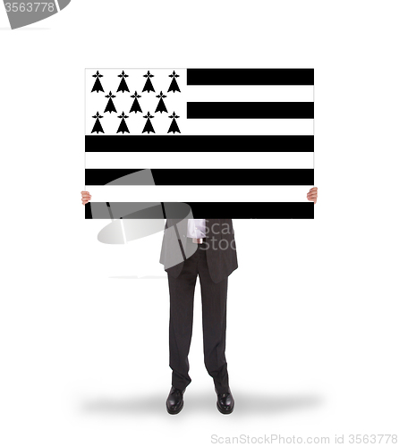 Image of Smiling businessman holding a big card, flag of Brittany