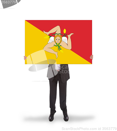 Image of Smiling businessman holding a big card, flag of Sicily