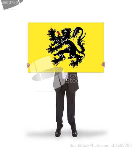 Image of Smiling businessman holding a big card, flag of Flanders
