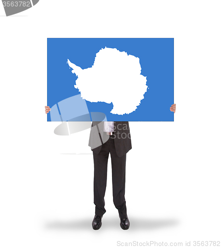 Image of Smiling businessman holding a big card, flag of Antarctica