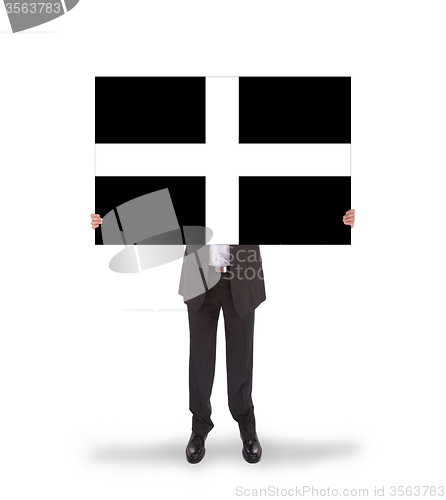 Image of Smiling businessman holding a big card, flag of Cornwall