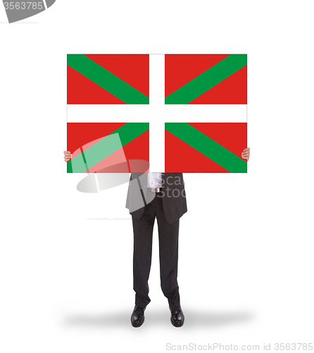 Image of Smiling businessman holding a big card, flag of Basque Country