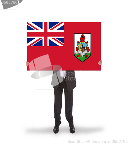 Image of Smiling businessman holding a big card, flag of Bermuda