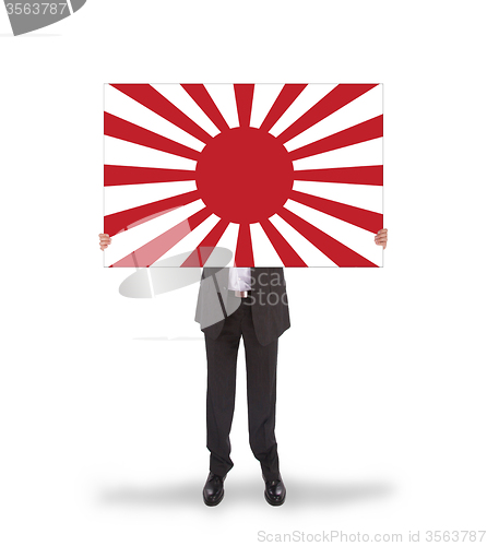 Image of Smiling businessman holding a big card, flag of Japan