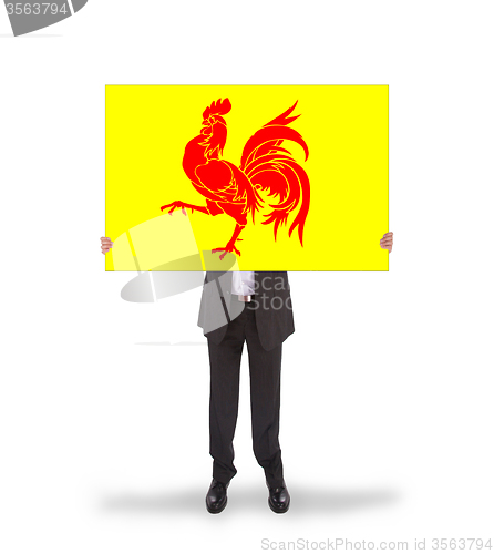 Image of Smiling businessman holding a big card, flag of Wallonia