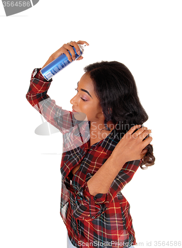 Image of African american woman using hair spray.