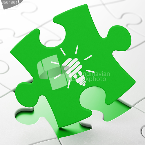 Image of Business concept: Energy Saving Lamp on puzzle background