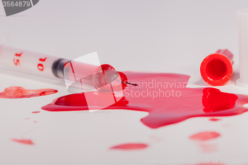 Image of Syringe Squirting Red Blood onto White Background