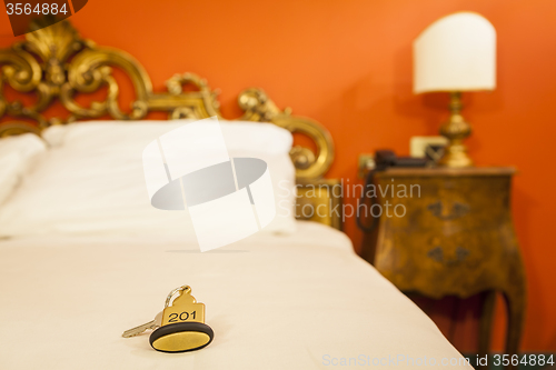 Image of Hotel Room Key lying on Bed with keyring