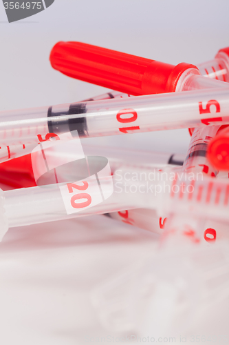 Image of Pile of Empty Syringes with Red Safety Caps