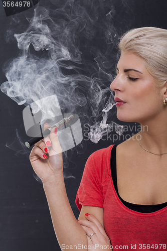 Image of Stylish blond woman smoking an e-cigarette