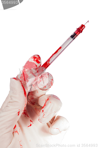 Image of Bloody gloved hand holding a syringe