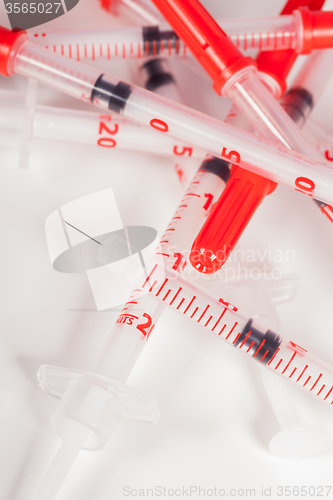 Image of Pile of Empty Syringes with Red Safety Caps