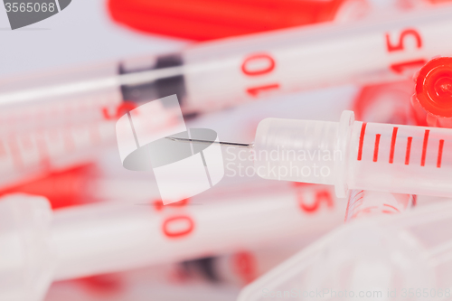 Image of Pile of Empty Syringes with Red Safety Caps