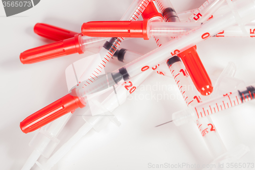 Image of Pile of Empty Syringes with Red Safety Caps