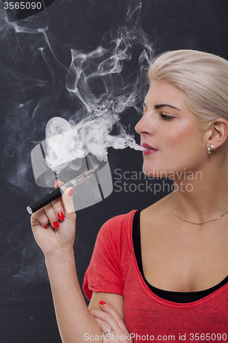 Image of Stylish blond woman smoking an e-cigarette