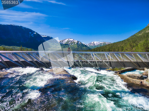 Image of Girl on bridge above waterfall