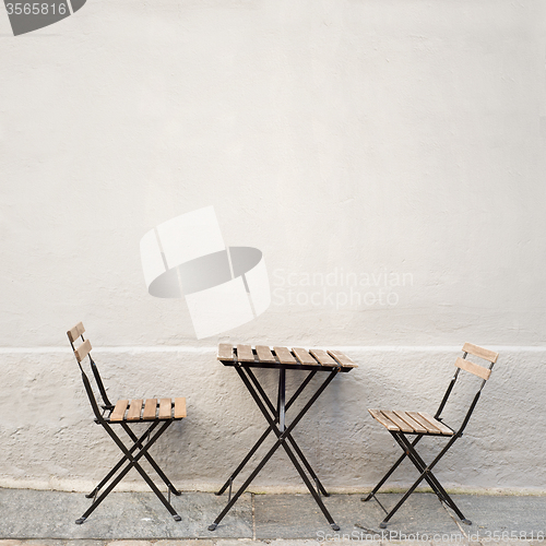 Image of table and two chairs near the wall