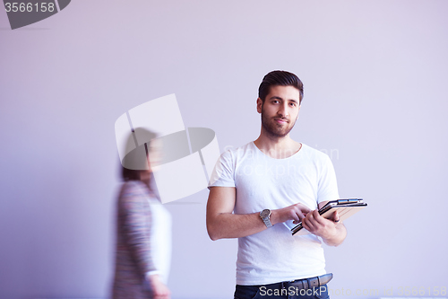 Image of student working on tablet, people group passing by