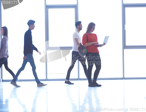 Image of student girl standing with laptop, people group passing by