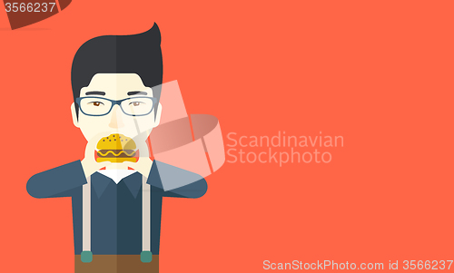 Image of Man eating hamburger. 