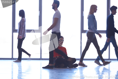 Image of student girl standing with laptop, people group passing by