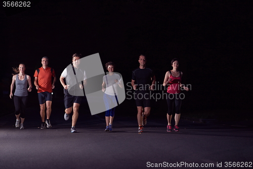 Image of people group jogging at night