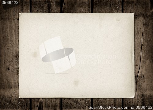 Image of Old textured paper sheet on a dark wood table