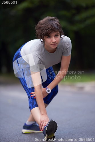 Image of woman  stretching before morning jogging