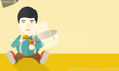Image of Man eating hamburger. 
