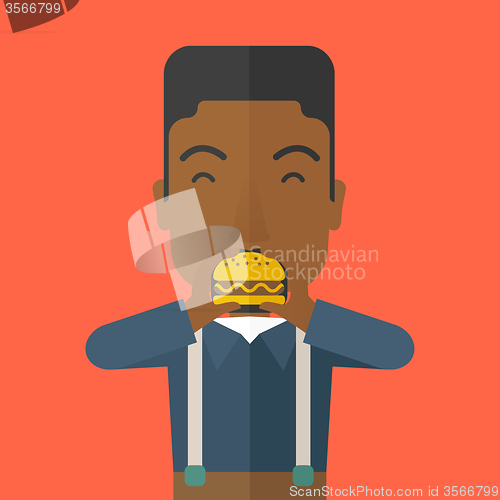 Image of Man eating hamburger. 