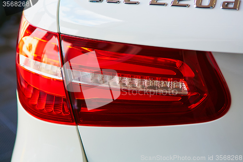 Image of Back view and red headlight of white automobile