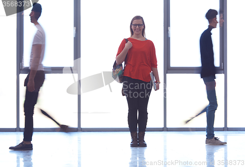 Image of student girl standing with laptop, people group passing by