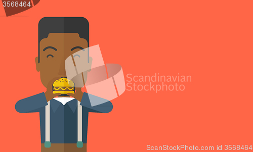 Image of Man eating hamburger. 
