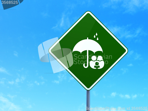 Image of Protection concept: Family And Umbrella on road sign background