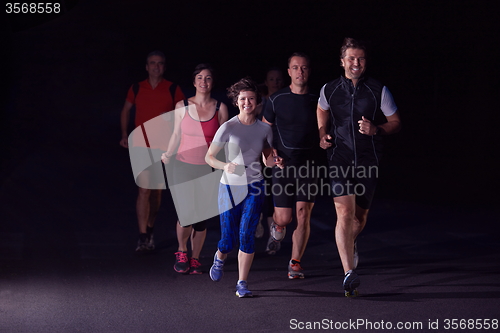 Image of people group jogging at night